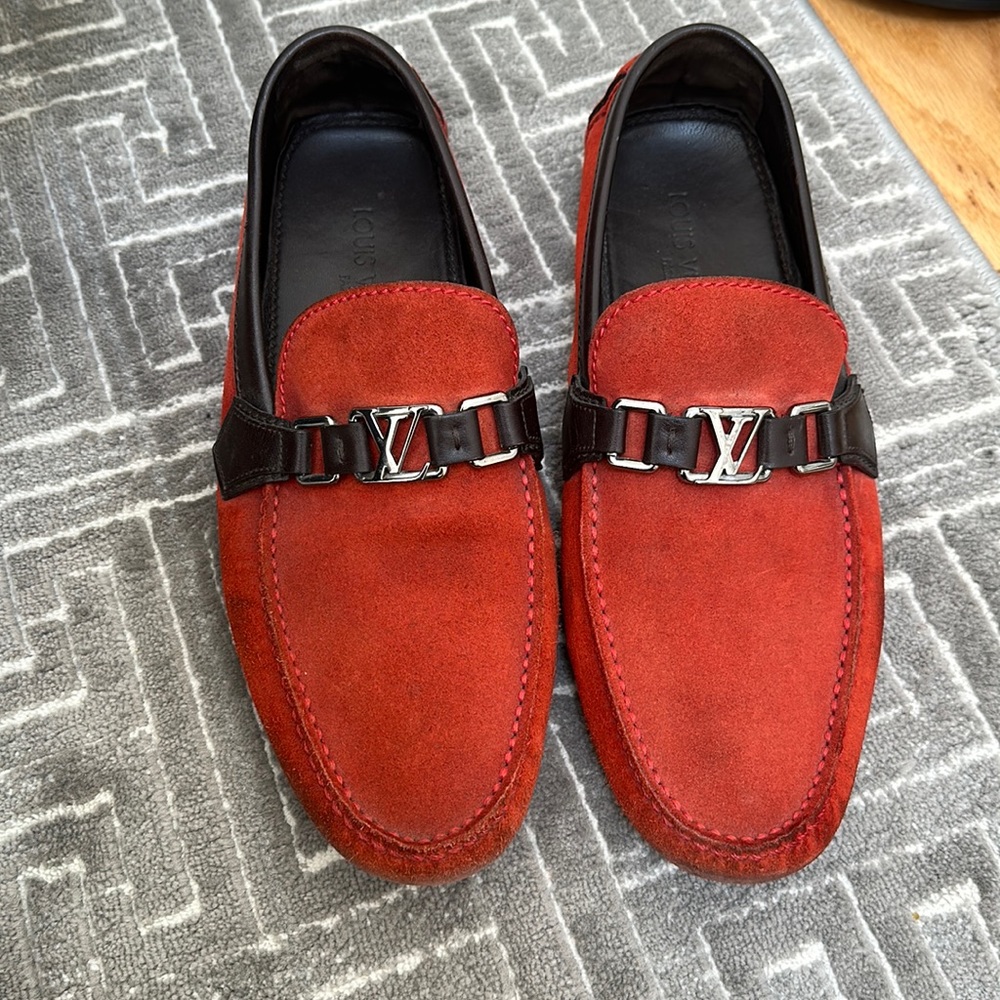 Men’s Louis Vuitton loafers in red suede with brown leather trimming details.